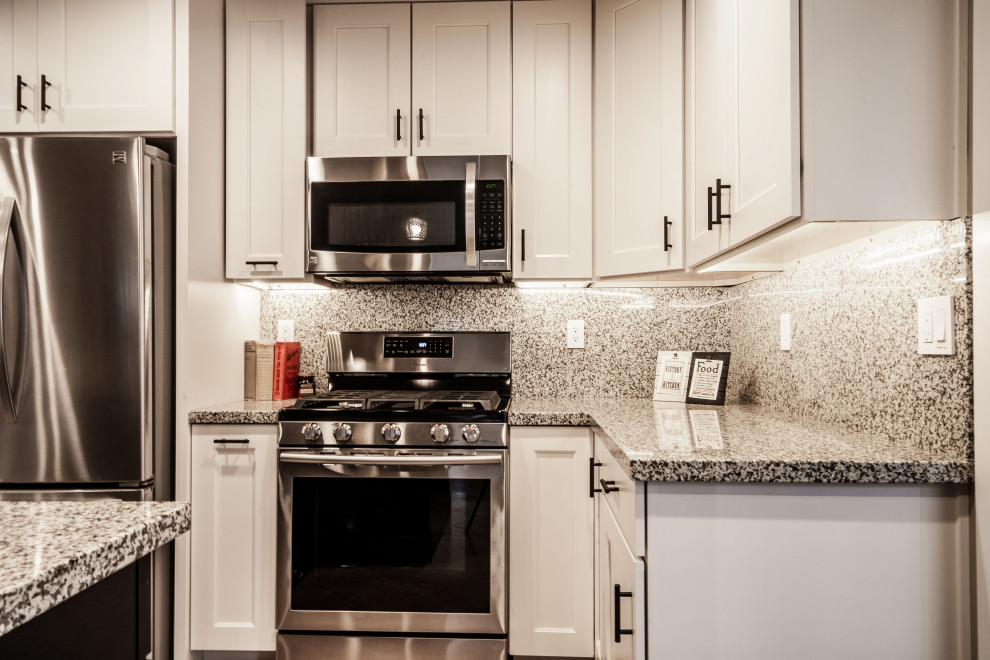 Large transitional medium tone wood floor and red floor open concept kitchen photo in Phoenix with an undermount sink, shaker cabinets, white cabinets, granite countertops, multicolored backsplash, granite backsplash, stainless steel appliances, an island and multicolored countertops
