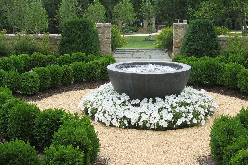 Photo of a large traditional front yard full sun formal garden in DC Metro with a garden path and gravel.