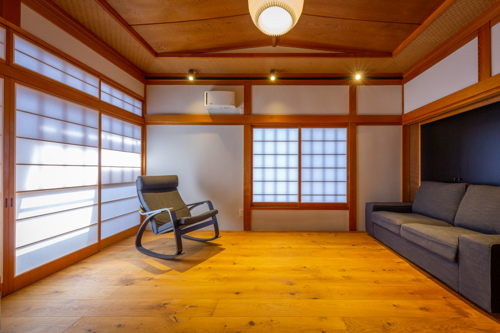 Esempio di una cameretta da letto con pareti bianche, pavimento in legno massello medio e soffitto in legno