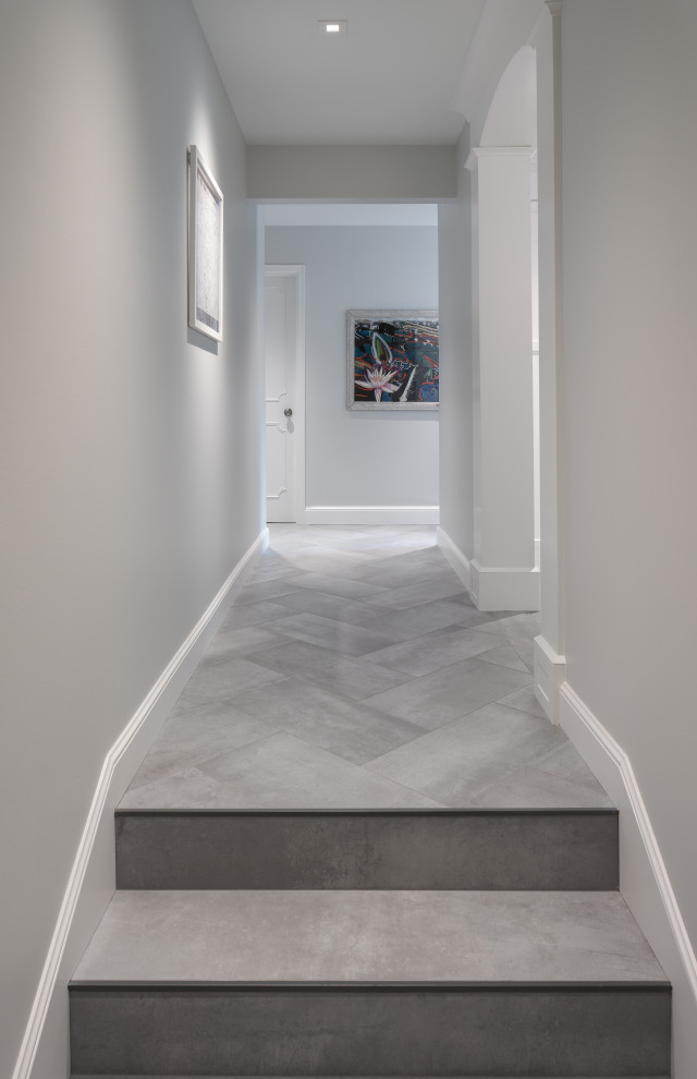 Cette photo montre un petit couloir tendance avec un mur gris, un sol en carrelage de porcelaine et un sol gris.
