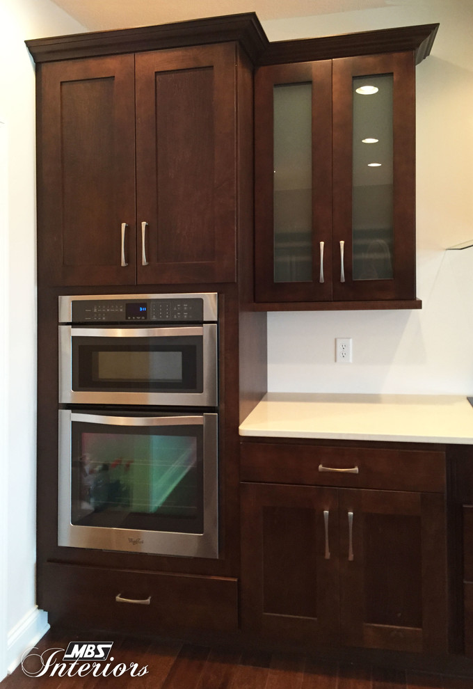 Eat-in kitchen - large transitional medium tone wood floor and brown floor eat-in kitchen idea with an undermount sink, shaker cabinets, stainless steel appliances, dark wood cabinets and a peninsula