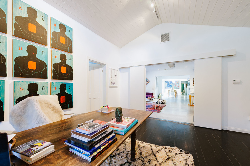 Design ideas for an expansive eclectic home studio in Los Angeles with white walls, a standard fireplace, a brick fireplace surround, a freestanding desk, dark hardwood floors and black floor.