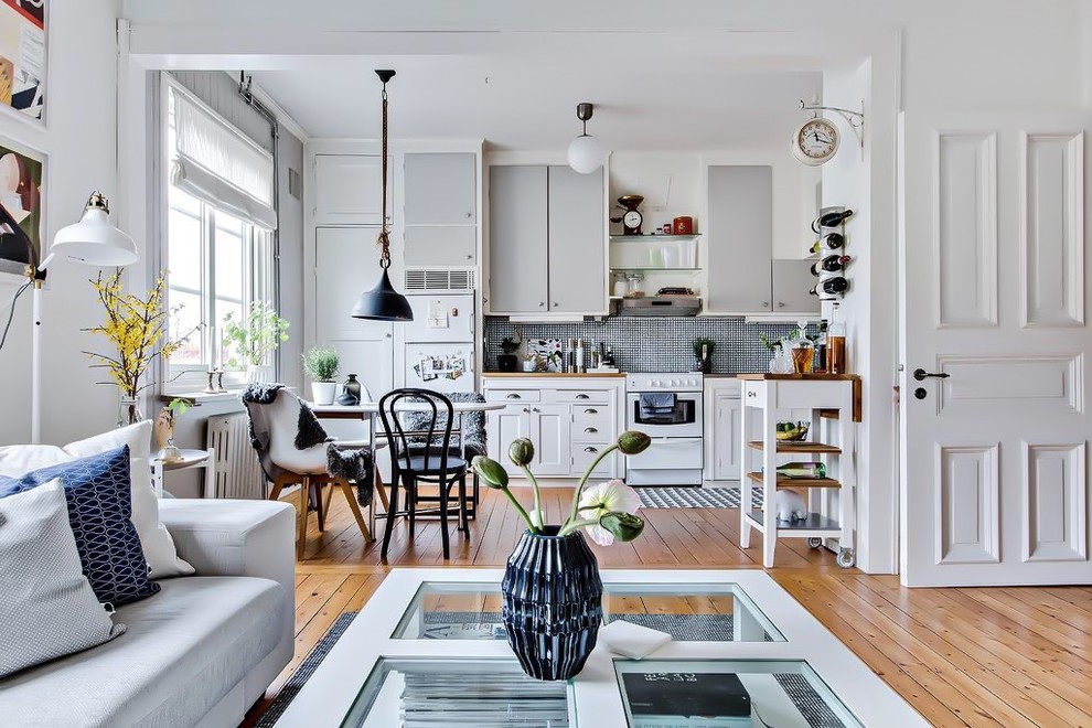 Inspiration for a mid-sized scandinavian single-wall open plan kitchen in Gothenburg with wood benchtops, multi-coloured splashback, white appliances, medium hardwood floors, no island and beige floor.