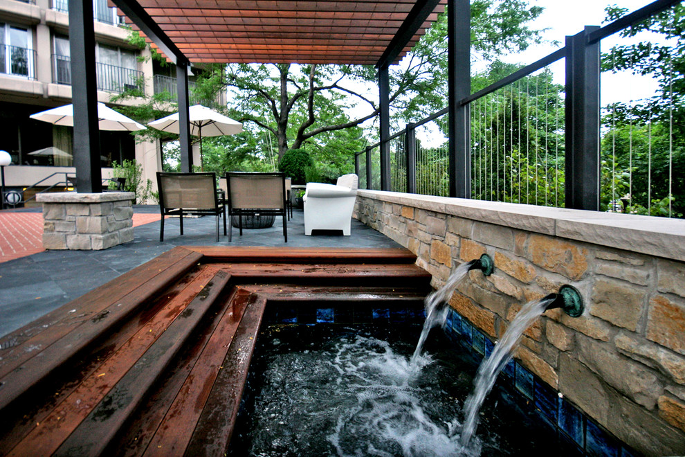 Design ideas for a large contemporary backyard patio in Chicago with a water feature and a pergola.