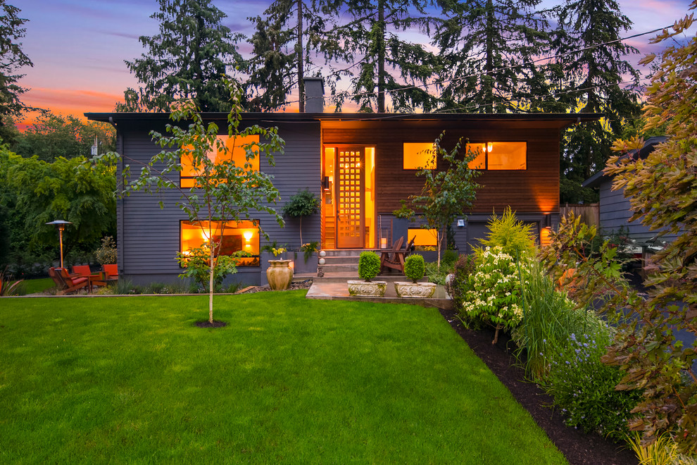 Photo of a mid-sized contemporary split-level grey exterior in Seattle with wood siding and a gable roof.