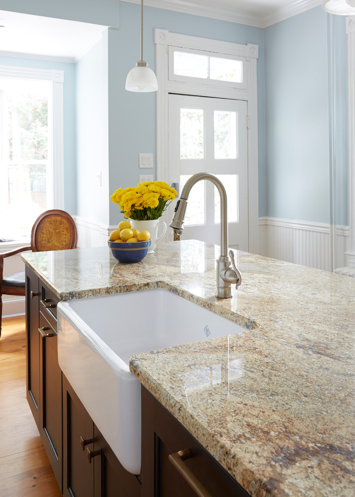 Inspiration for a transitional medium tone wood floor eat-in kitchen remodel in DC Metro with a farmhouse sink, recessed-panel cabinets, white cabinets, granite countertops, white backsplash, subway tile backsplash, stainless steel appliances and an island