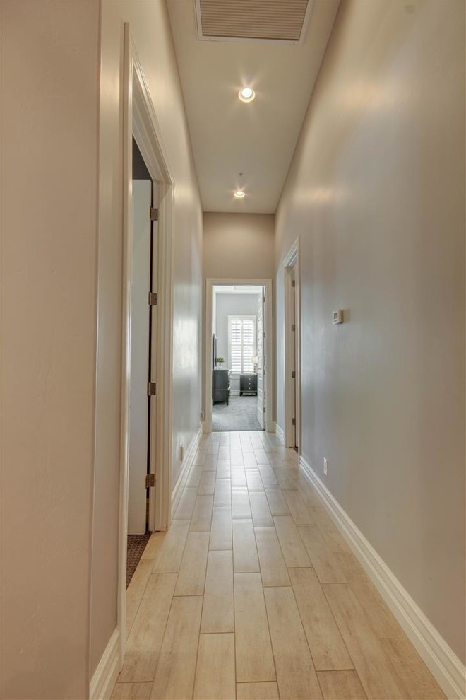 Small arts and crafts hallway in Phoenix with beige walls and light hardwood floors.