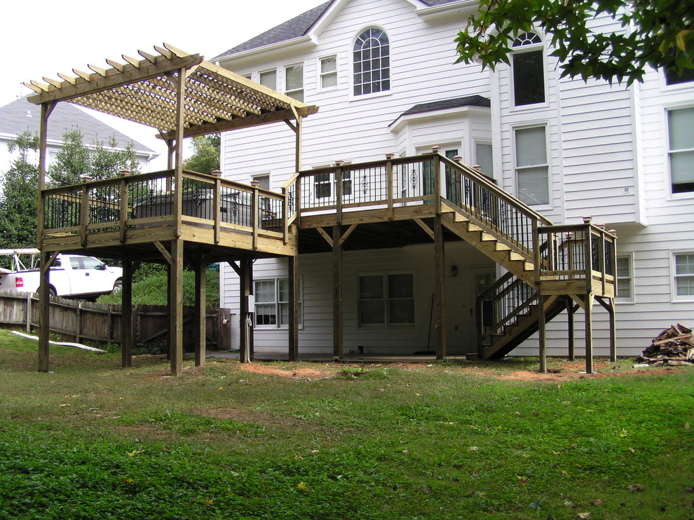 Example of a large mountain style backyard balcony deck design in Atlanta with a pergola