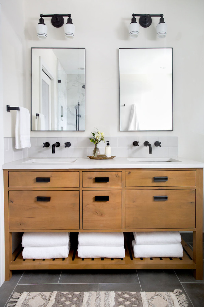 Inspiration for a large transitional master bathroom in Calgary with flat-panel cabinets, medium wood cabinets, white tile, white walls, an undermount sink, grey floor, white benchtops, a freestanding tub, porcelain floors and engineered quartz benchtops.