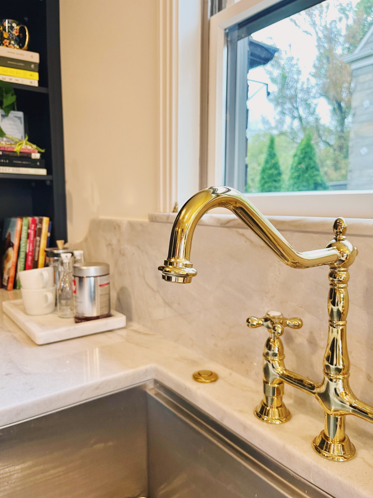 Example of a large transitional l-shaped medium tone wood floor and brown floor eat-in kitchen design with an undermount sink, shaker cabinets, blue cabinets, quartzite countertops, stone slab backsplash, paneled appliances, no island and gray countertops