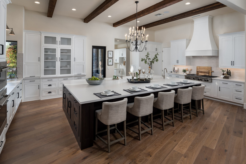 Design ideas for a kitchen in Phoenix with shaker cabinets, white cabinets, grey splashback, stainless steel appliances, medium hardwood floors, with island and white benchtop.