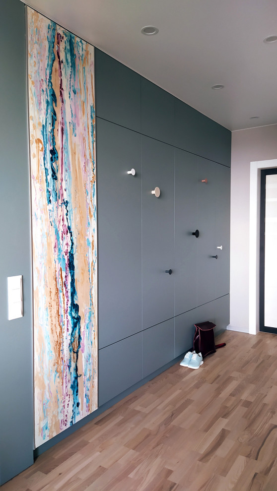 Idées déco pour une entrée scandinave de taille moyenne avec un couloir, un mur beige, un sol en bois brun, une porte simple et une porte blanche.