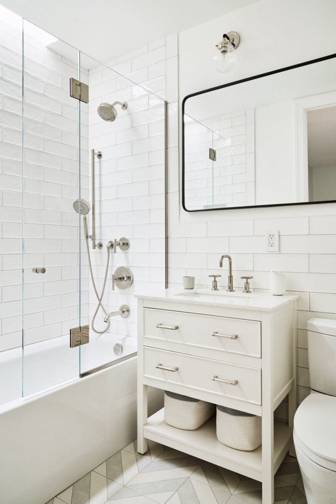 Пример оригинального дизайна: детская ванная комната в стиле неоклассика (современная классика) с ванной в нише, душем над ванной, унитазом-моноблоком, белой плиткой, плиткой кабанчик, белыми стенами, полом из керамической плитки, подвесной раковиной, серым полом, душем с распашными дверями, тумбой под одну раковину и подвесной тумбой