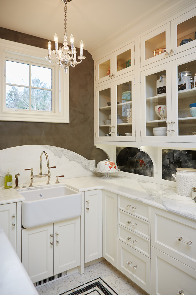 Inspiration for a traditional u-shaped kitchen pantry in Grand Rapids with white cabinets, marble benchtops, marble splashback, ceramic floors, multi-coloured floor, a farmhouse sink, glass-front cabinets and white splashback.