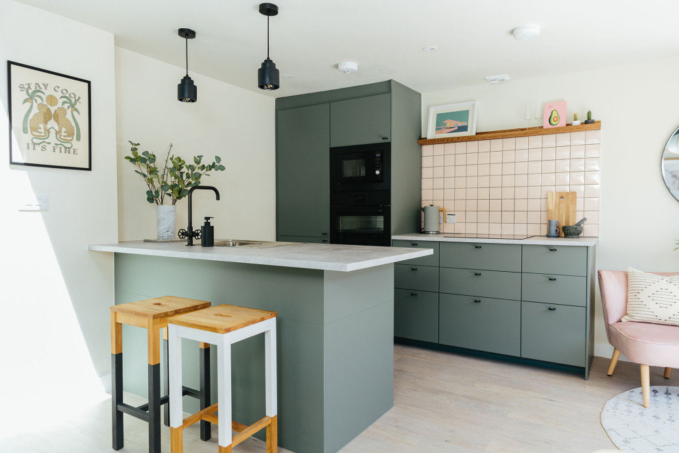 Inspiration for a medium sized scandinavian kitchen in Dorset with green cabinets, black appliances and an island.