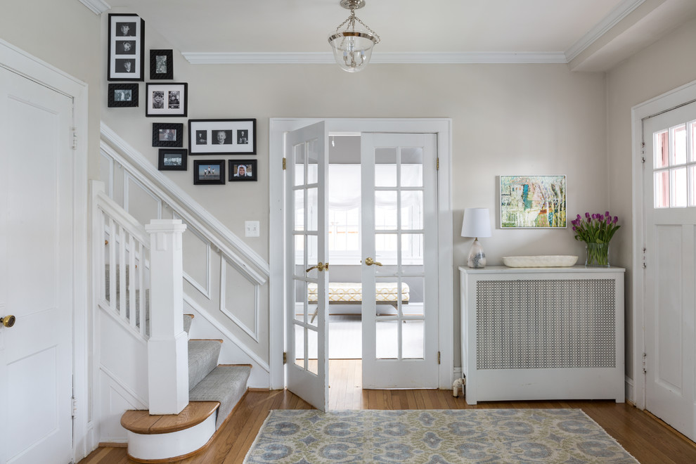 This is an example of a transitional foyer in DC Metro with beige walls, light hardwood floors, a single front door and a white front door.