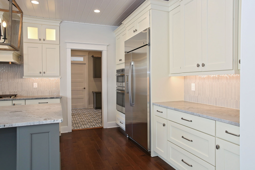 Foto på ett lantligt vit kök, med skåp i shakerstil, stänkskydd med metallisk yta, stänkskydd i stickkakel och en köksö