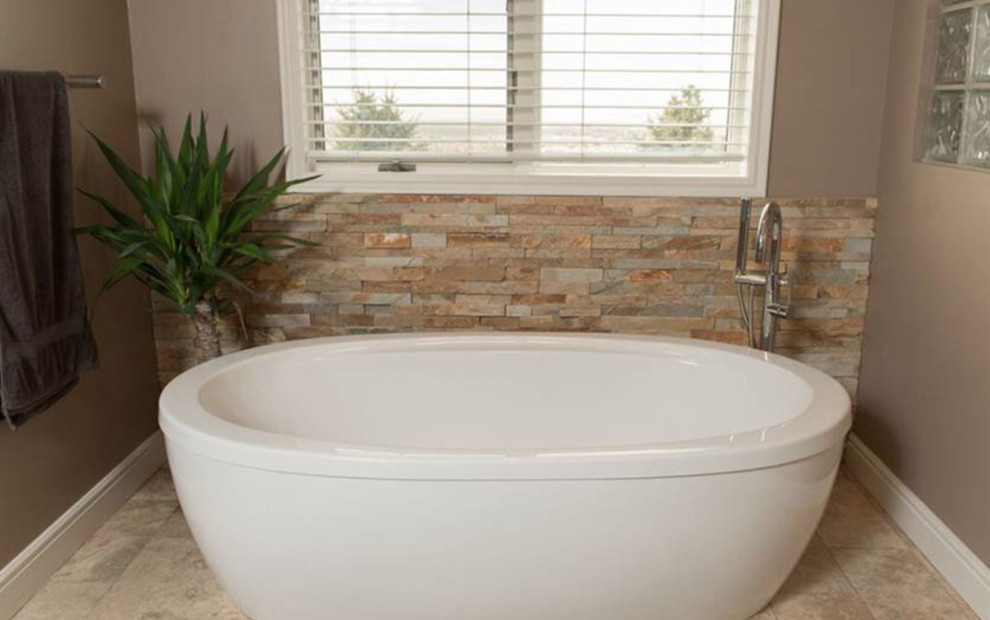 Example of a large transitional master freestanding bathtub design with beige walls