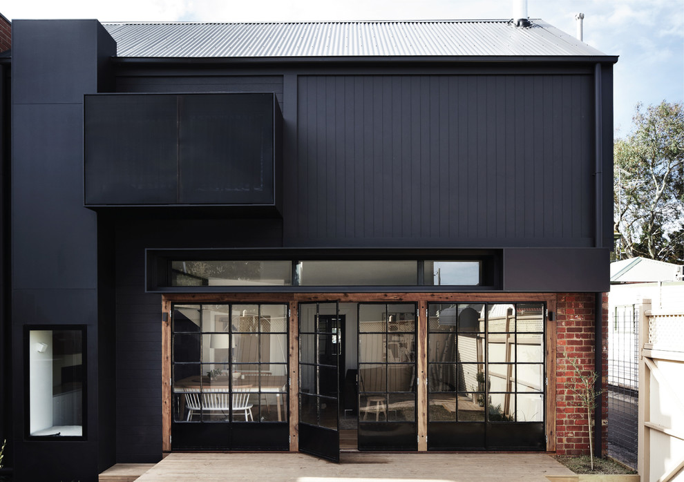 Photo of a contemporary two-storey black exterior in Melbourne with mixed siding.