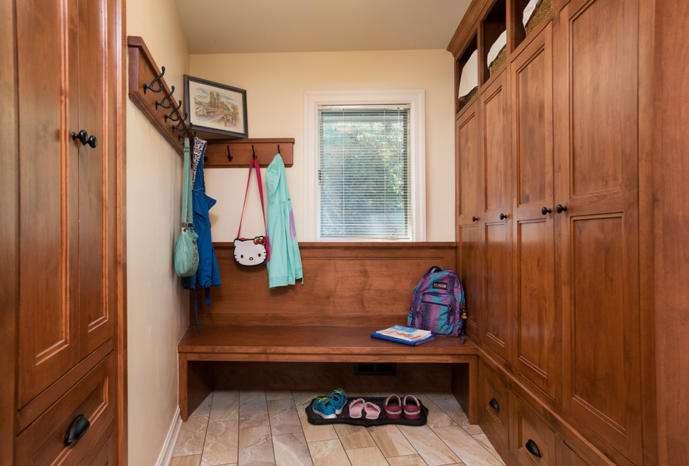 Photo of a small transitional mudroom in Minneapolis with beige walls and porcelain floors.