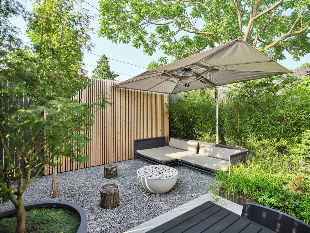 Photo of a small contemporary back formal partial sun garden for summer in Toronto with a garden path, concrete paving and a wood fence.