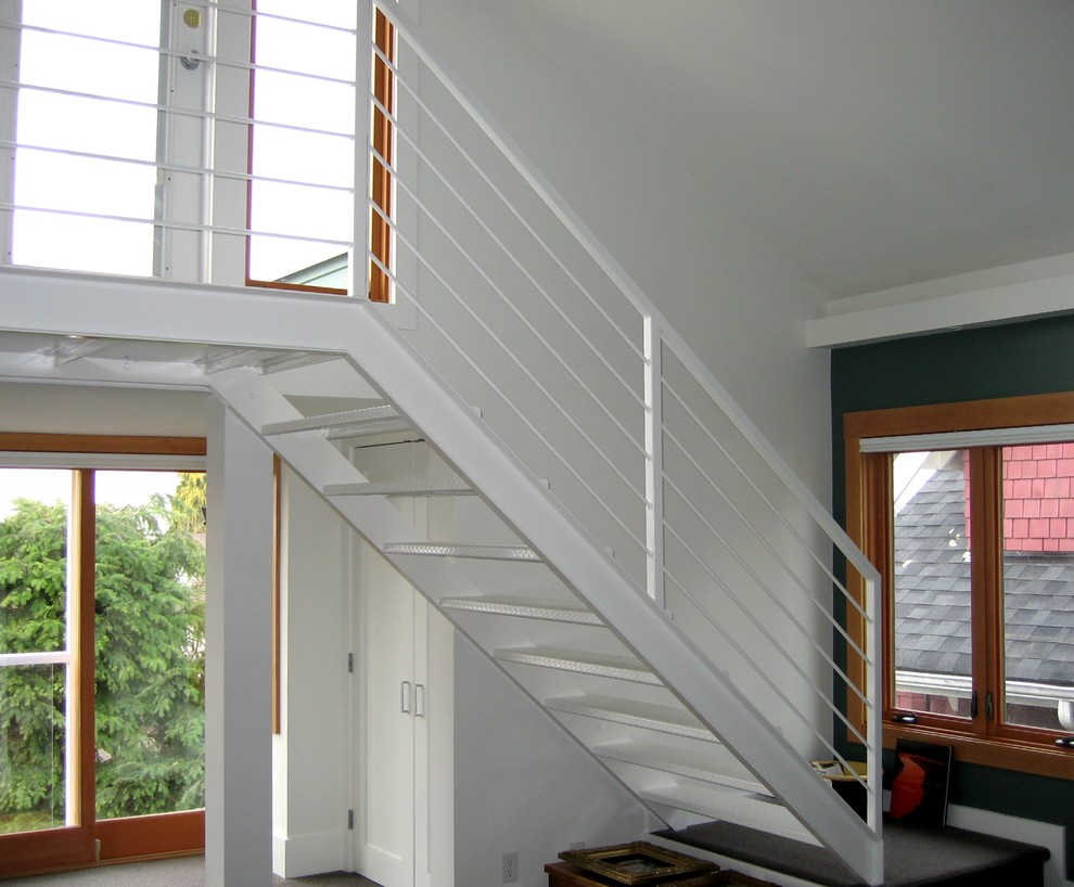 Photo of a large modern metal straight staircase in Vancouver with open risers and metal railing.