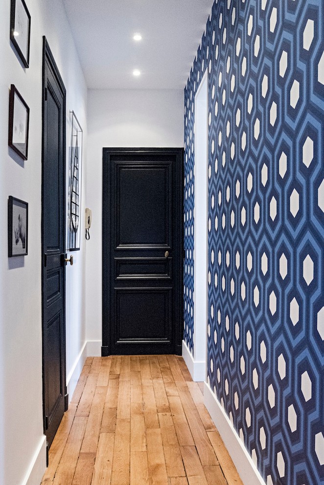This is an example of a mid-sized transitional hallway in Paris with blue walls and light hardwood floors.