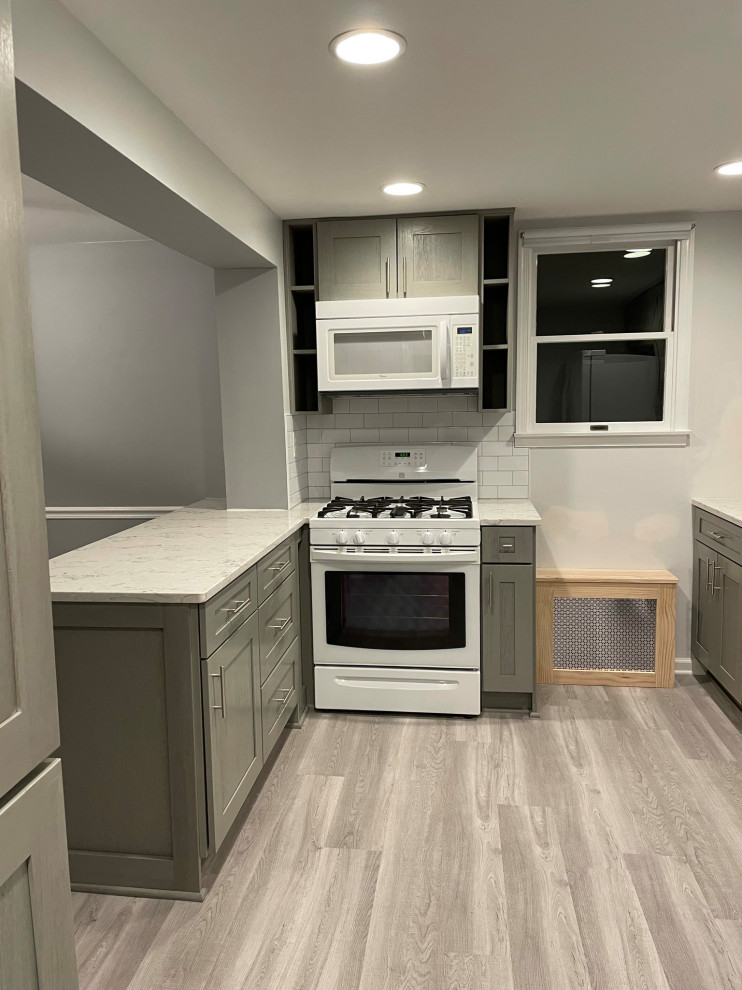 Photo of a small grey and white galley kitchen pantry in DC Metro with shaker cabinets, grey cabinets, quartz worktops, white appliances, vinyl flooring, multiple islands, grey floors and multicoloured worktops.
