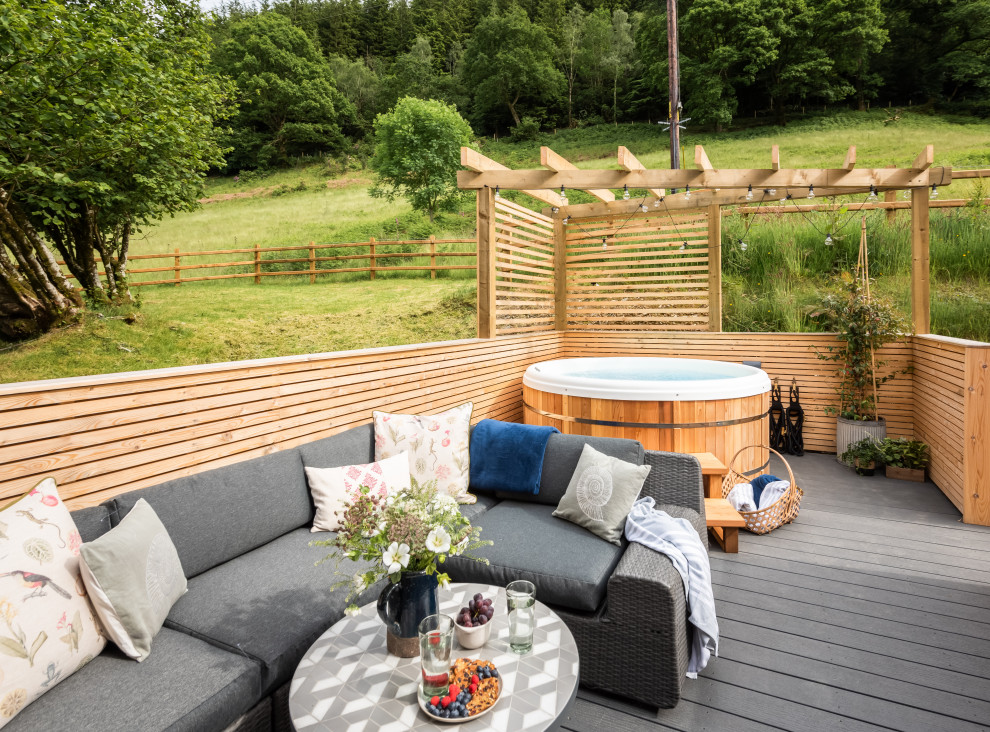 Modelo de terraza de estilo de casa de campo pequeña en patio trasero con pérgola y barandilla de madera