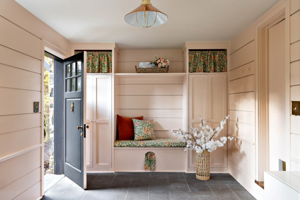 Inspiration for a large country mudroom in New York with pink walls, slate floors, a single front door, a black front door, planked wall panelling and grey floor.