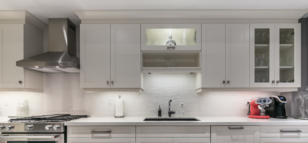 Eat-in kitchen - mid-sized transitional l-shaped porcelain tile eat-in kitchen idea in Toronto with a drop-in sink, recessed-panel cabinets, white cabinets, quartz countertops, stainless steel appliances and an island