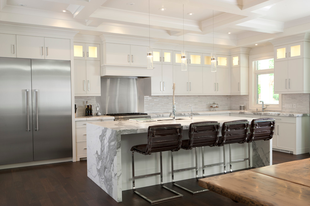 Design ideas for a large transitional l-shaped open plan kitchen in Toronto with a double-bowl sink, recessed-panel cabinets, white cabinets, marble benchtops, white splashback, stone tile splashback, stainless steel appliances, dark hardwood floors and with island.