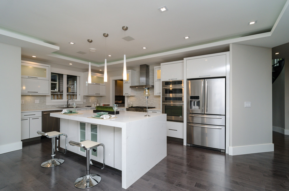 Inspiration for a modern eat-in kitchen in Vancouver with an undermount sink, flat-panel cabinets, white cabinets, quartz benchtops, grey splashback, stainless steel appliances, medium hardwood floors and with island.