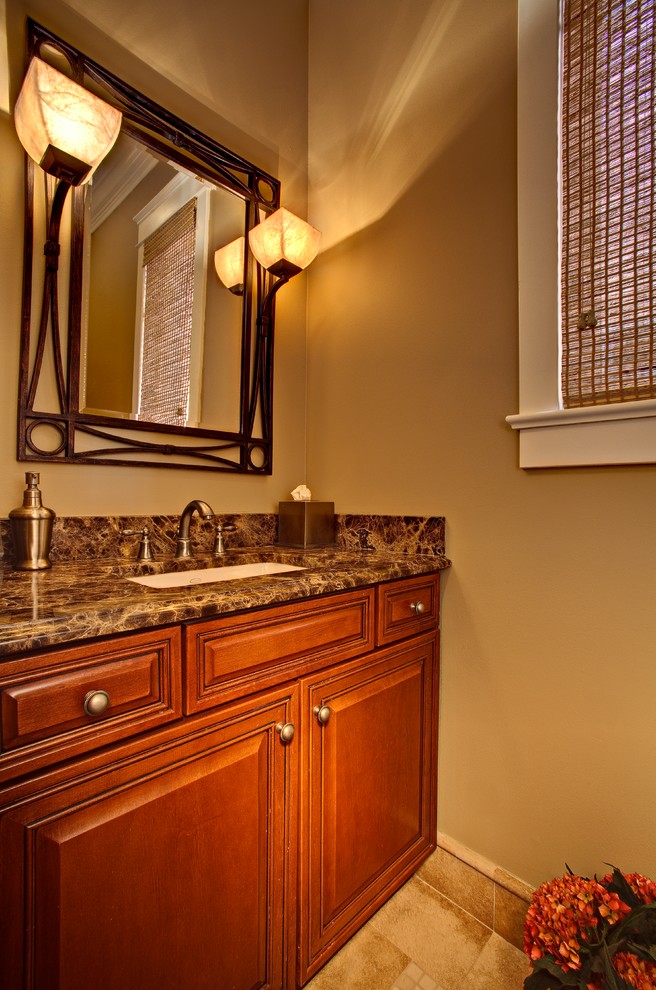 Photo of a small traditional bathroom in Chicago with raised-panel cabinets, medium wood cabinets, a two-piece toilet, beige tile, porcelain tile, beige walls, porcelain floors, an undermount sink and granite benchtops.