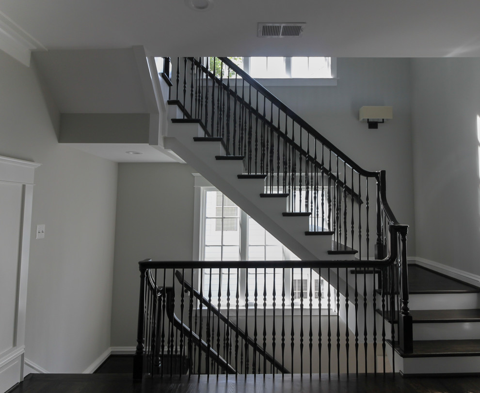 Photo of a large transitional wood floating staircase in DC Metro with wood risers and mixed railing.