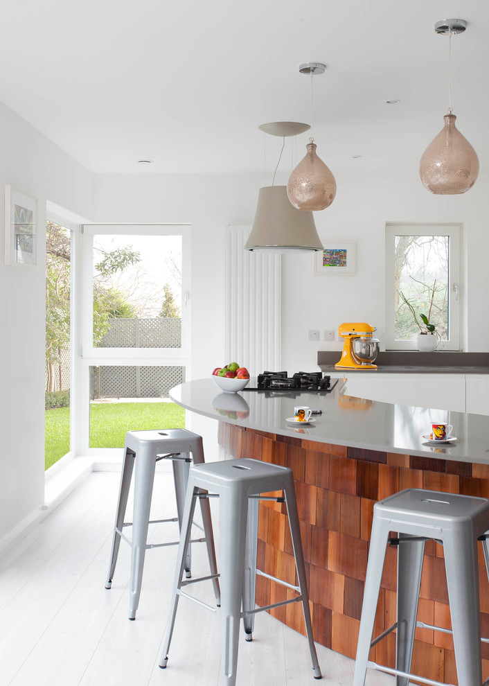 Photo of a large contemporary l-shaped open plan kitchen in Other with an undermount sink, flat-panel cabinets, white cabinets, quartzite benchtops, grey splashback, stone slab splashback, stainless steel appliances, light hardwood floors and with island.