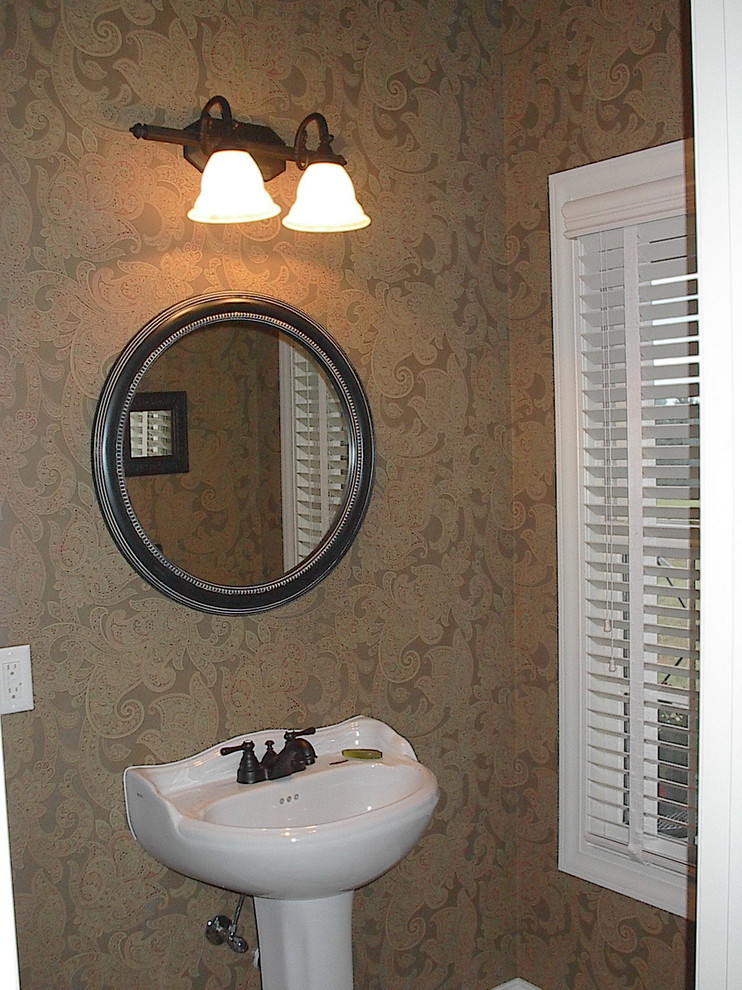 Example of a small transitional bathroom design with brown walls and a pedestal sink