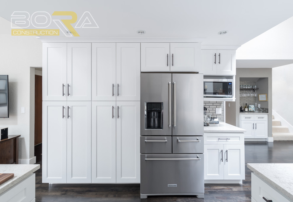Mid-sized transitional u-shaped dark wood floor and brown floor eat-in kitchen photo with an undermount sink, recessed-panel cabinets, white cabinets, wood countertops, metallic backsplash, ceramic backsplash, stainless steel appliances and a peninsula