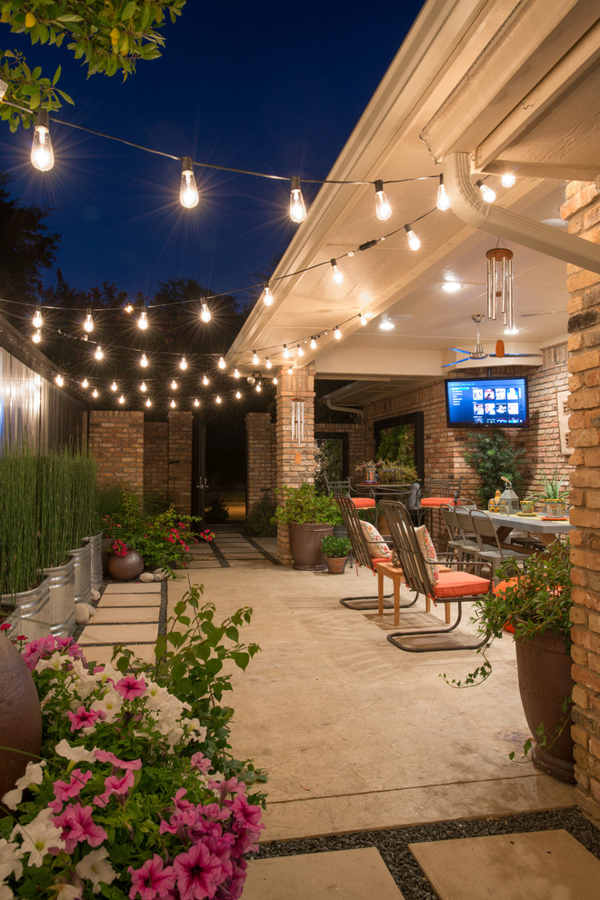 Design ideas for an eclectic side yard patio in Dallas with a container garden, stamped concrete and a roof extension.