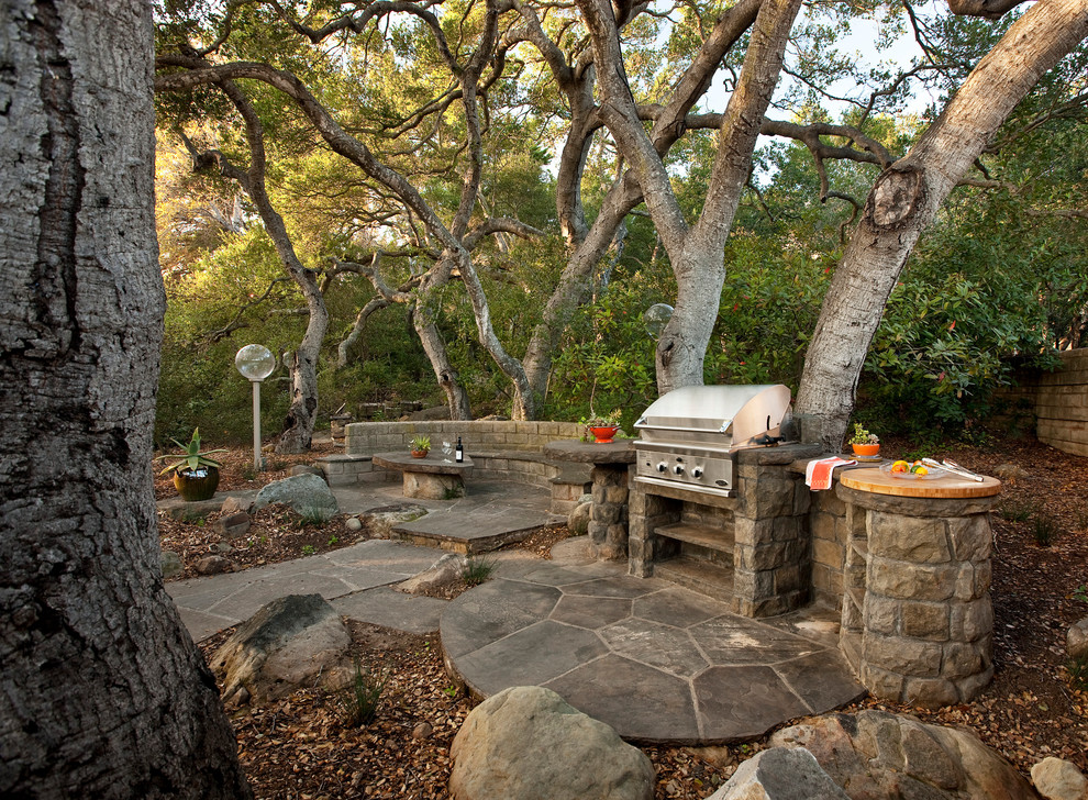 This is an example of a traditional patio in Santa Barbara with natural stone pavers and no cover.
