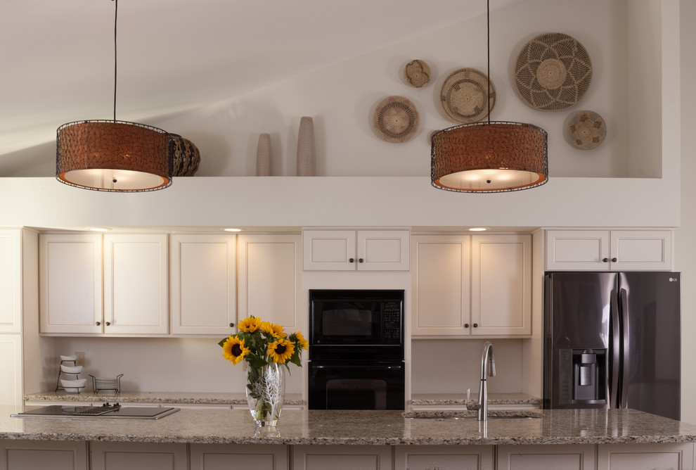 Example of a mid-sized mountain style galley porcelain tile and beige floor open concept kitchen design with an undermount sink, recessed-panel cabinets, white cabinets, quartz countertops, black appliances, an island and beige countertops