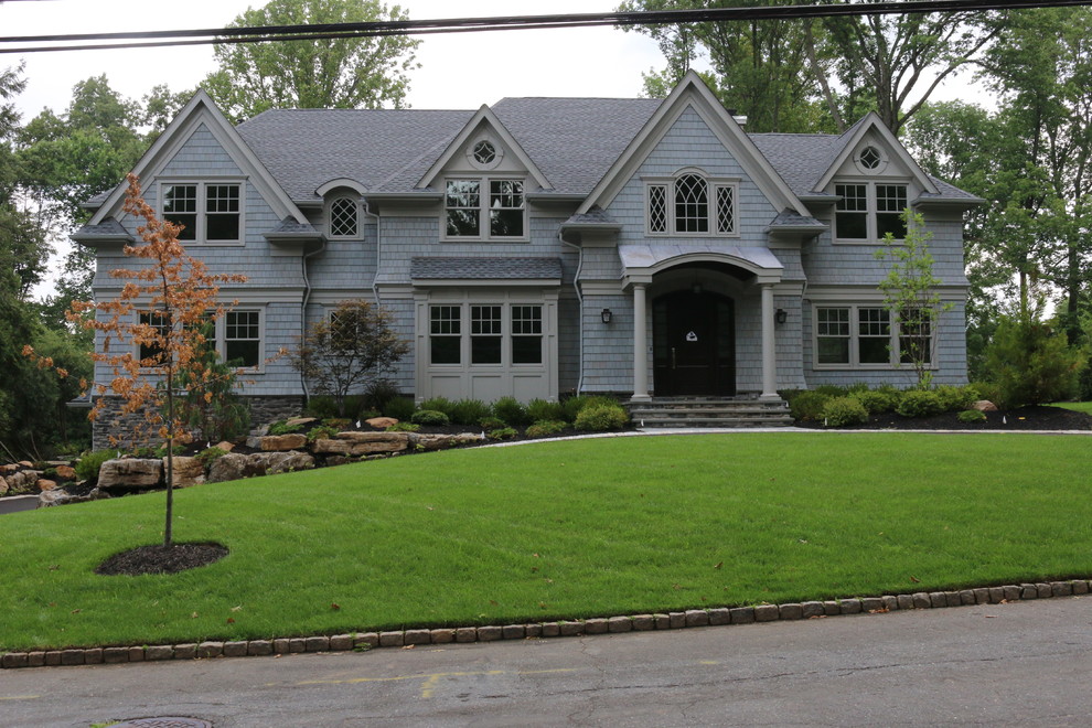 Photo of an expansive traditional two-storey grey exterior in New York with wood siding and a gable roof.