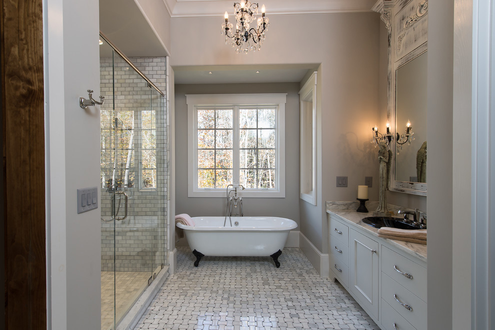 Inspiration for a large rustic master gray tile and ceramic tile ceramic tile claw-foot bathtub remodel with gray cabinets, gray walls, a drop-in sink, recessed-panel cabinets, a one-piece toilet and granite countertops
