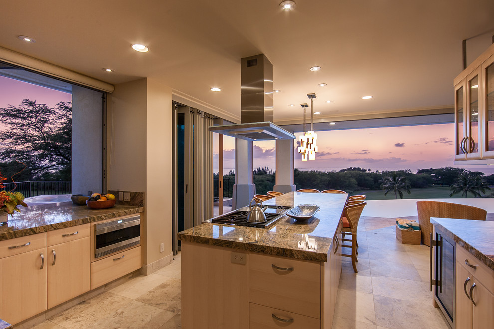 Large tropical u-shaped open plan kitchen in Hawaii with glass-front cabinets, brown cabinets, limestone benchtops, beige splashback, travertine floors, with island and beige floor.