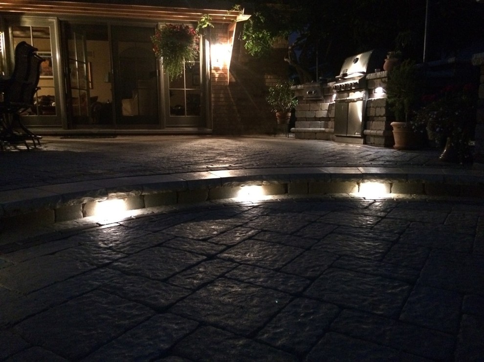Photo of a large transitional backyard patio in Chicago with an outdoor kitchen, natural stone pavers and no cover.
