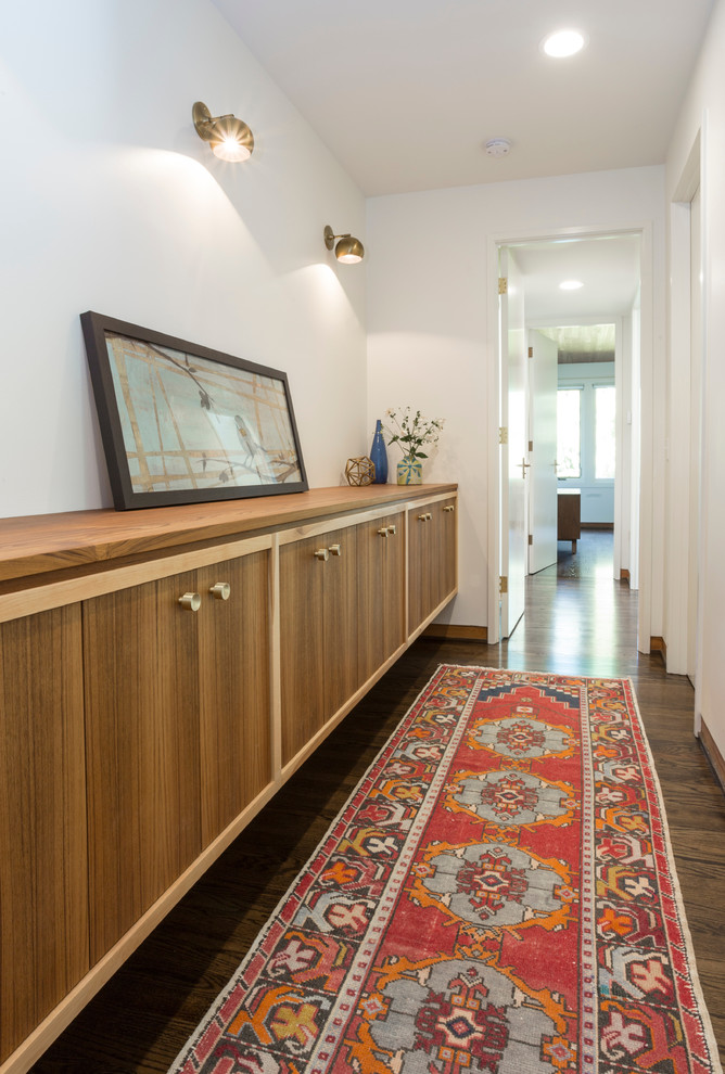 Photo of a large midcentury hallway in Portland with white walls, dark hardwood floors and brown floor.