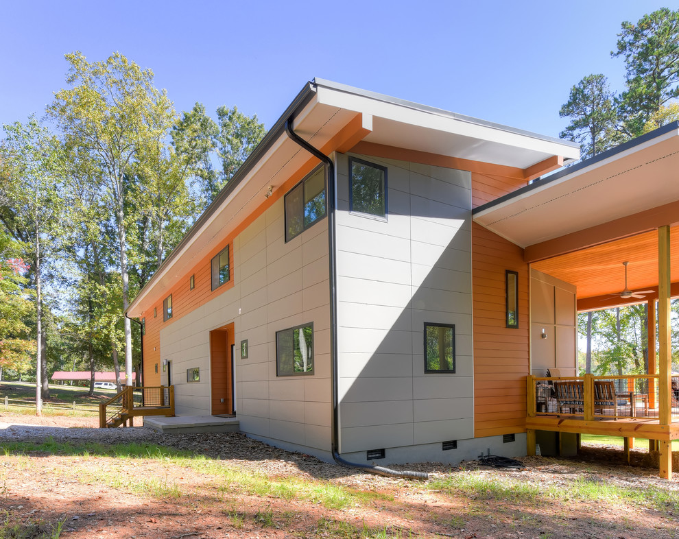 Diseño de fachada naranja actual de tamaño medio de dos plantas con revestimientos combinados y tejado de un solo tendido