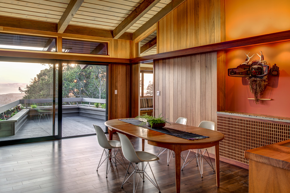 This is an example of a midcentury dining room in San Francisco with dark hardwood floors.