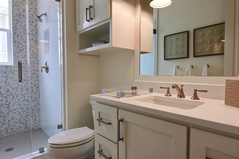 Mid-sized beach style bathroom in Austin with shaker cabinets, white cabinets, an alcove shower, a one-piece toilet, white tile, porcelain tile, white walls, porcelain floors, an undermount sink, quartzite benchtops, grey floor and a hinged shower door.