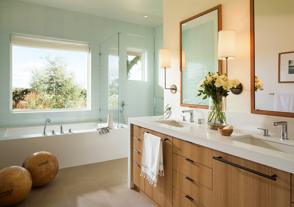 This is an example of a contemporary master bathroom in San Francisco with an undermount sink, flat-panel cabinets, medium wood cabinets, an undermount tub, a corner shower and beige walls.